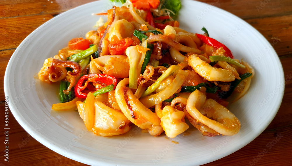 Stir fried fresh squid with eggs with yolk sauce with chilli and onion Stir fried fresh squid with eggs with yolk sauce with chilli and onion