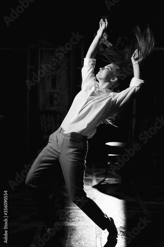 Black and white portrait of beautiful dancing caucasian girl with dramatical emotion on the stage.Retro fashion. Black and white image. © Naz