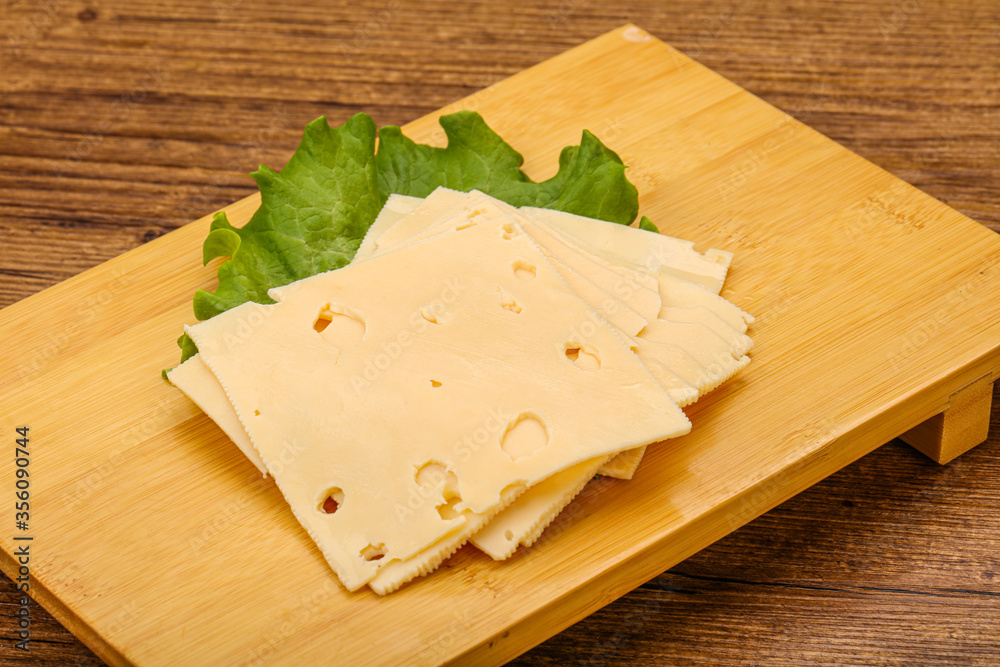 Sliced yellow cheese over board