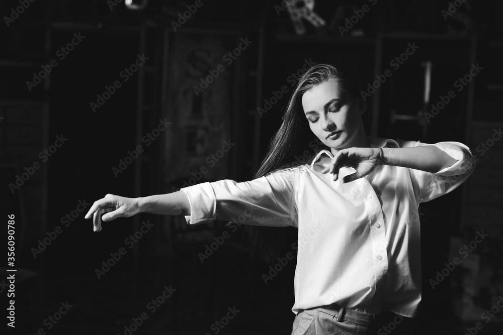 Black and white portrait of beautiful dancing caucasian girl with dramatical emotion on the stage.Retro fashion. Black and white image.
