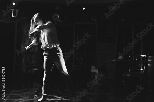Black and white portrait of beautiful dancing caucasian girl with dramatical emotion on the stage.Retro fashion. Black and white image. © Naz