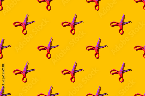 Seamless pattern of open figure scissors on orange background. Flat lay view. Hard light.