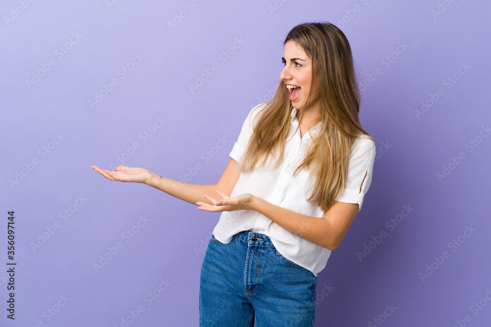Young woman over isolated purple background with surprise expression while looking side Young woman over isolated purple background with surprise expression while looking side