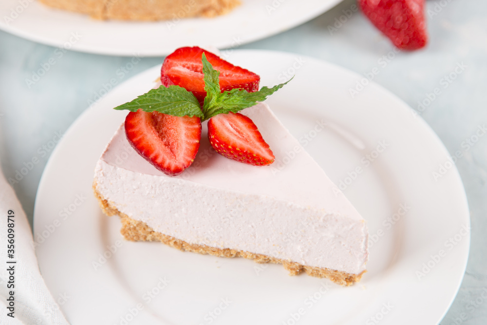 Sweet breakfast, delicious cheesecake with fresh strawberries and mint, homemade recipe without baking, on a blue stone table. Copy space. Sweet breakfast, delicious cheesecake with fresh strawberries and mint, homemade recipe without baking, on a blue stone table. Copy space.