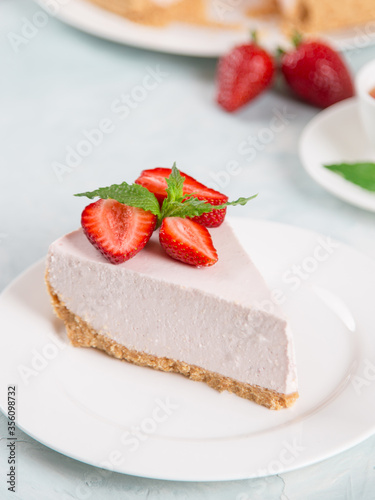 Sweet breakfast  tea and delicious cheesecake with fresh strawberries and mint  homemade recipe without baking  on a blue stone table. Copy space.
