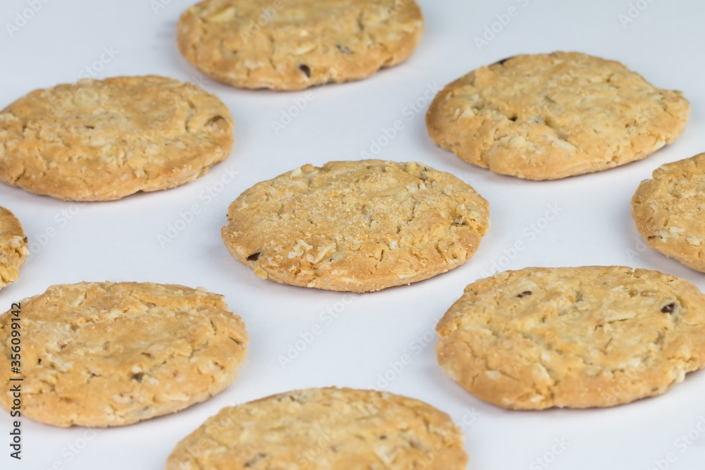 Closeup cereal cookies are arranged in multiple pieces and have three rows, and the cookies are brown and the image has a blank area next to the object and has a white background.