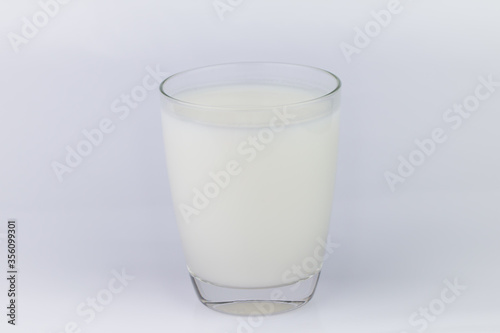 The cow's milk close-up is refreshing white In a clear glass container The image has blank space beside the object and has a white background. The image is partially clear.