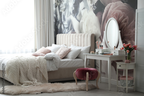 Stylish bedroom interior with elegant dressing table and floral wallpaper