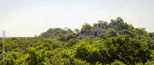 Ancient Maya ruins of Calakmul in the thick jungle and tree landscapes on a sunny day in the Yucatán Peninsula of Mexico. photo