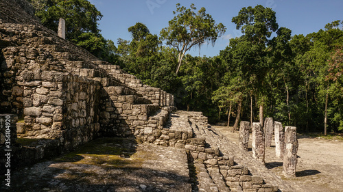 Ancient Maya ruins of Calakmul in the thick jungle and tree landscapes on a sunny day in the Yucatán Peninsula of Mexico.