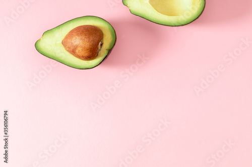Avocado minimal pattern. Border made of green avocado on light pink background. Flat lay, top view, copy space