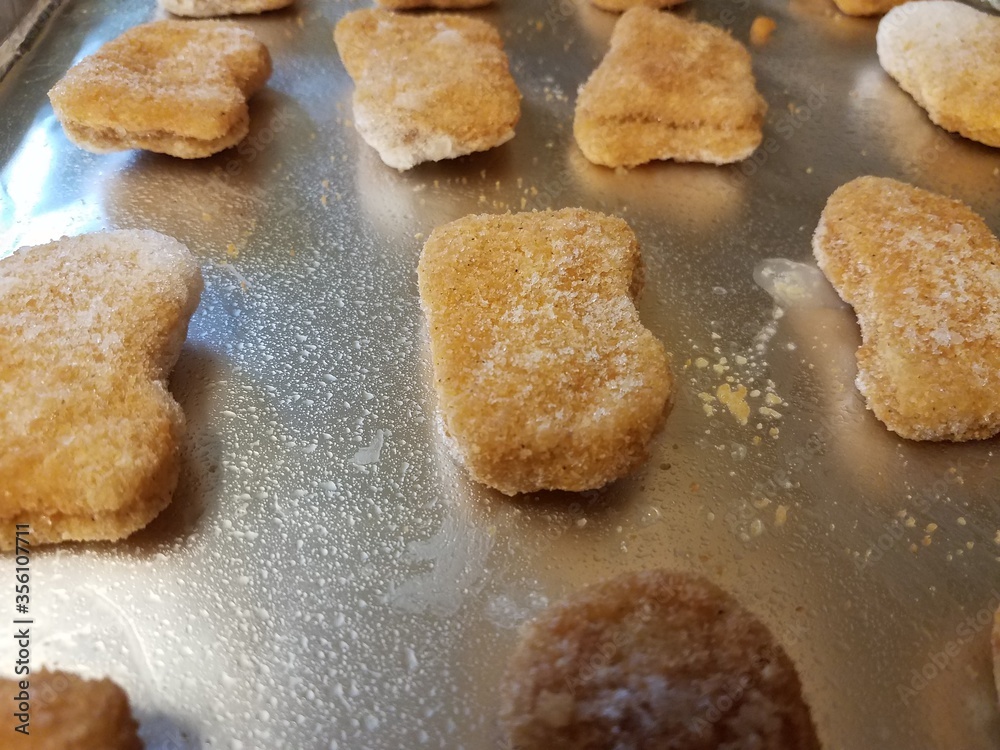 frozen chicken nuggets on foil on tray