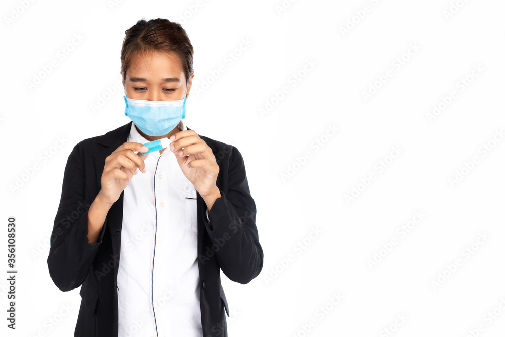 .Asian businesswoman wearing surgical face mask in black suit jacket, looking at small tube of blue sanitizer hand gel, studio light isolated on white background, coronavirus, COVID19 concept ....... .Asian businesswoman wearing surgical face mask in black suit jacket, looking at small tube of blue sanitizer hand gel, studio light isolated on white background, coronavirus, COVID19 concept .......