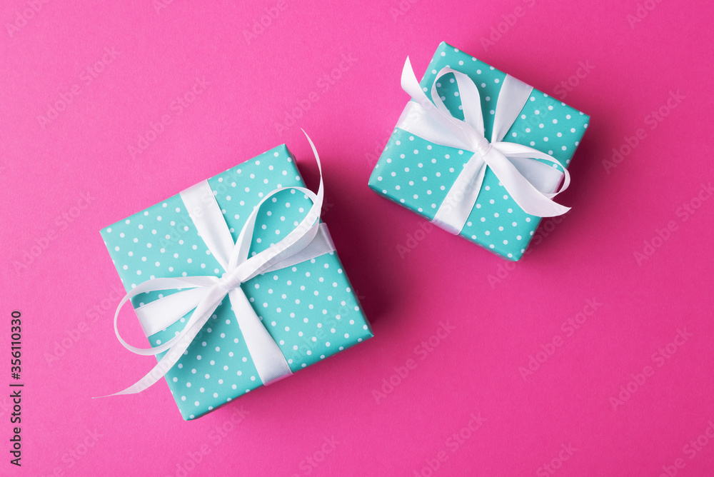 Fototapeta premium Big and small alike gift boxes on pink background