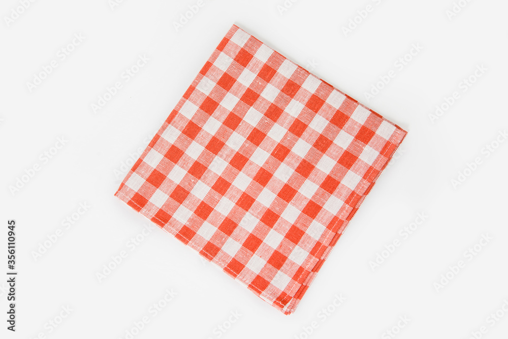 A square checkered napkin lies horizontally on a white background A square checkered napkin lies horizontally on a white background