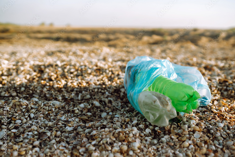 Bag with trash on a sandy beach. Concept of ecology and environmental protection.