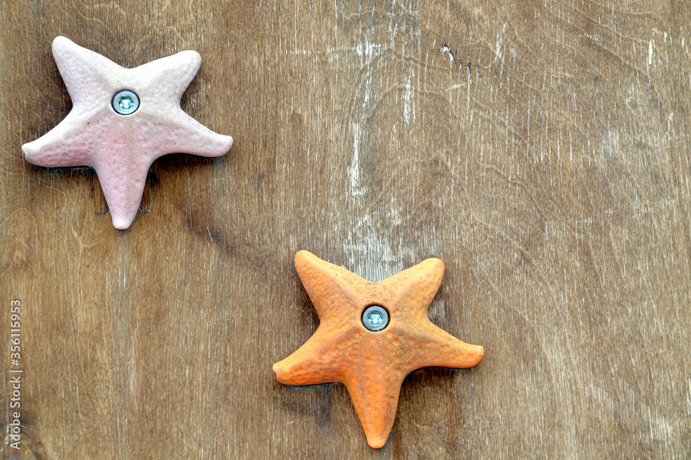 Orange and pink starfish toys on wooden background with copy space Orange and pink starfish toys on wooden background with copy space