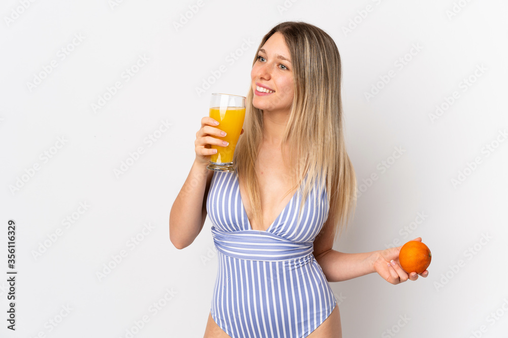 Young blonde woman isolated on white background in swimsuit and holding a cocktail Young blonde woman isolated on white background in swimsuit and holding a cocktail