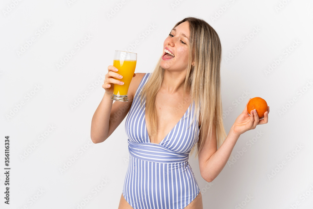 Young blonde woman isolated on white background in swimsuit and holding a cocktail Young blonde woman isolated on white background in swimsuit and holding a cocktail