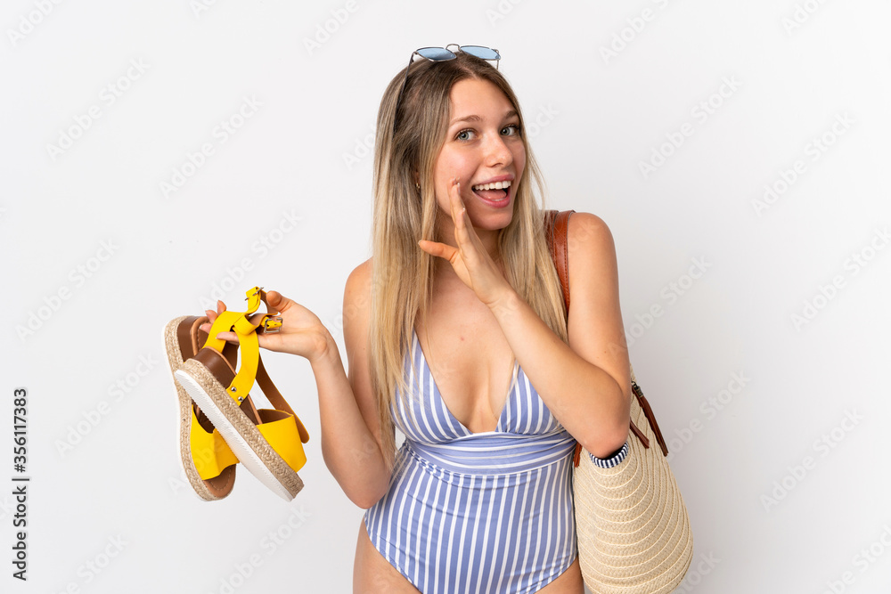 Obraz premium Young blonde woman holding summer sandals isolated on white background whispering something