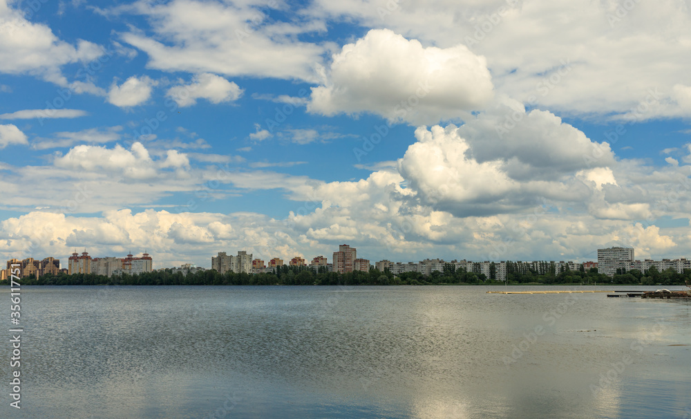 The landscape is a view of the lake with a clear blue sky and thick clouds. reflections in the water. It's a beautiful summer day. . High quality photo