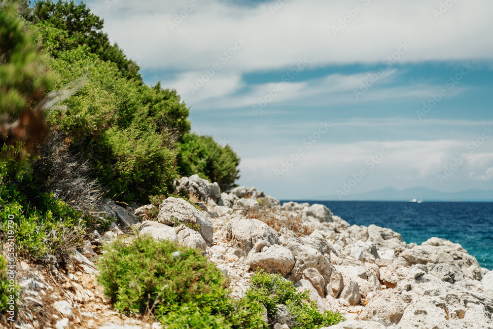 Seascape, Mediterranean coast. White rocks stones and blue water, sky with clouds