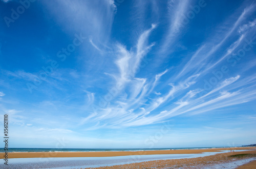 Beach view during the tide with cirrus clouds above. photo