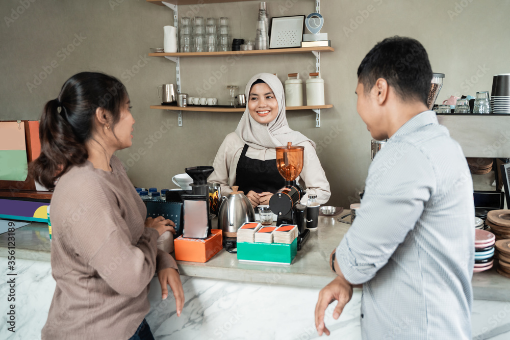Naklejka premium couple ordered coffee to the barista at the coffee shop