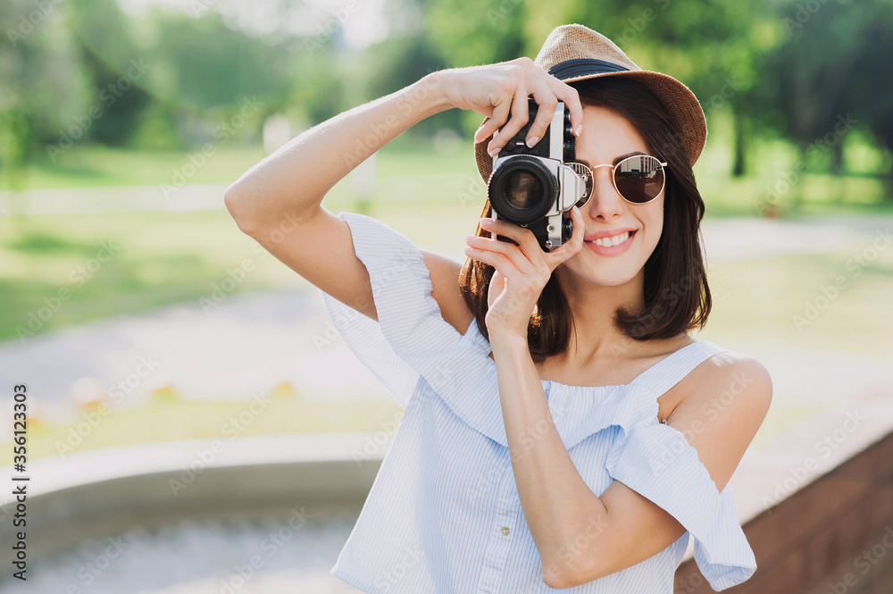 Young woman photographer takes photographs with camera in a city. Travel, vacations, hobby, leisure, work and active lifestyle concept Young woman photographer takes photographs with camera in a city. Travel, vacations, hobby, leisure, work and active lifestyle concept