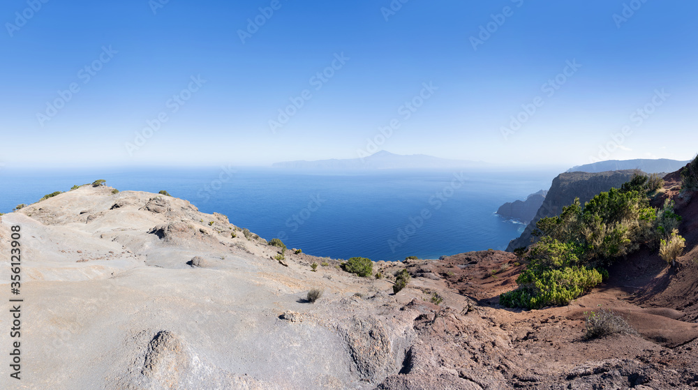 Graue Erosionslandschaft an der Nordküste von La Gomera oberhalb Agulo mit Blick zur Nachbarinsel Teneriffa