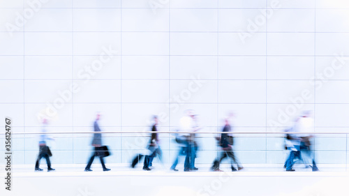 Group of unrecognizable business people in blurred motion