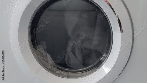 housework routine concept. clothes spinning inside a dryer laundry machine.