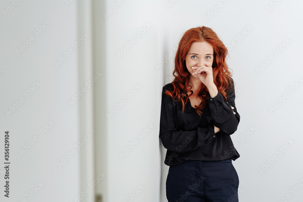 Embarrassed young woman chuckling to herself Embarrassed young woman chuckling to herself