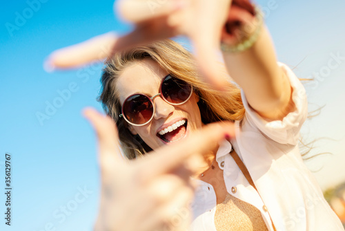 Happy young tourist smiling with sunglasses and camera