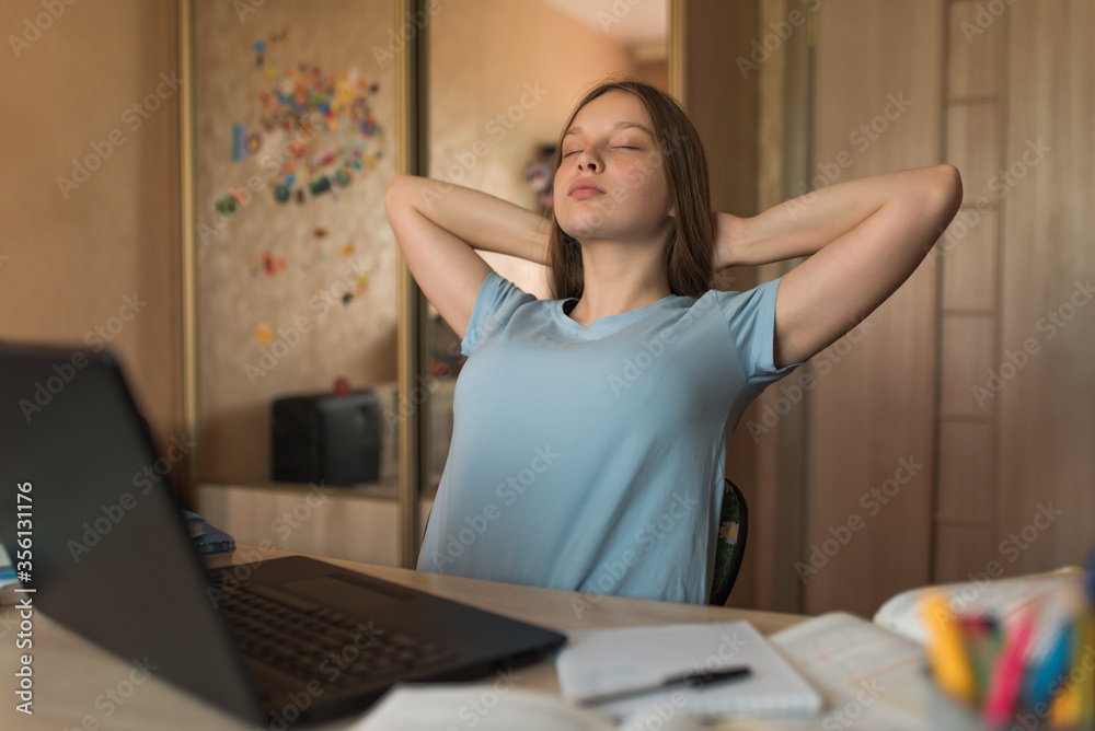 Teenager girl, neck gymnastics and sipping, online education at home with a laptop, emotions of pleasing pleasure and relaxation, break and rest from classes at school and institute. Teenager girl, neck gymnastics and sipping, online education at home with a laptop, emotions of pleasing pleasure and relaxation, break and rest from classes at school and institute.
