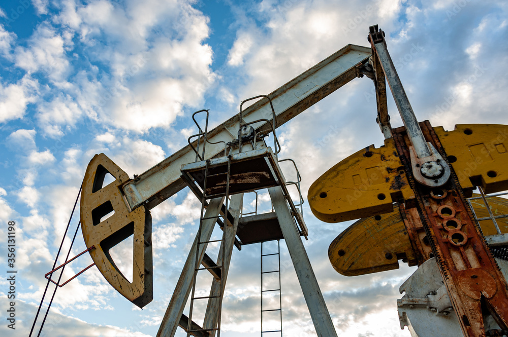 Oil pump rig. Oil and gas production. Oilfield site. Pump Jack are running. Drilling derricks for fossil fuels output and crude oil production. War on oil prices. Global coronavirus COVID 19 crisis. Oil pump rig. Oil and gas production. Oilfield site. Pump Jack are running. Drilling derricks for fossil fuels output and crude oil production. War on oil prices. Global coronavirus COVID 19 crisis.
