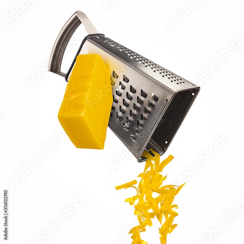 Grated cheese falling from metal grater isolated on white background
