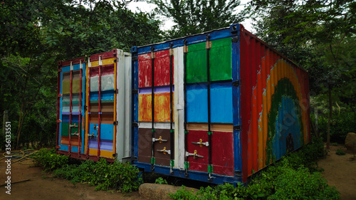 colorfully painted shipment container surrounded by trees