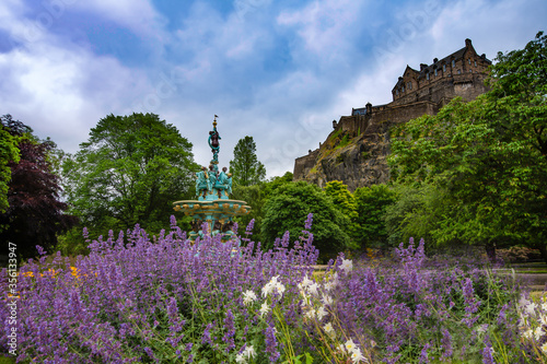view of Edinburgh castle from princess street gardens. ross fountain and flowers of the gardens with views to the castle beyond. Edinburgh, Scotland.