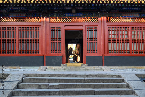 Red wooden window and door, decoration colorful painting beam and wood pole from ancient china palace in forbidden City, Beijing, China
