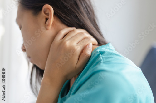 Young woman feeling exhausted and suffering from neck pain, Health concept