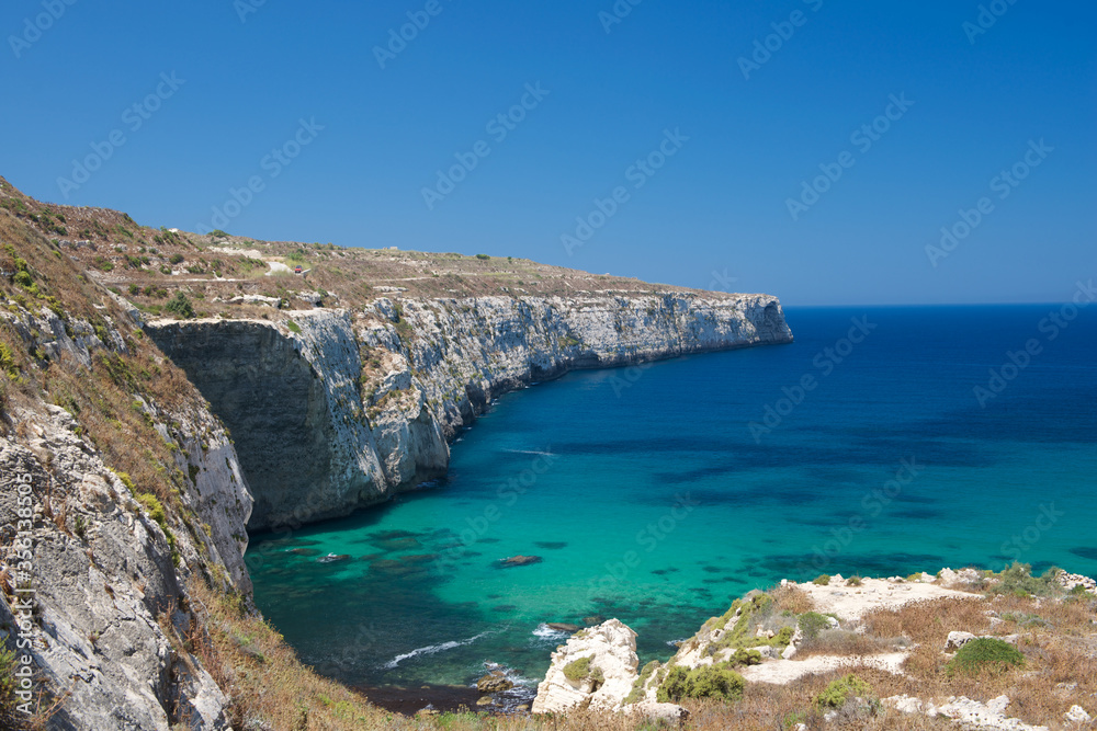 Maltese coastline with the cliffs,gold rocks over the sea in the Malta island with the blue clear sky background,Malta, nice bay in Malta,maltese nature, Bahrija