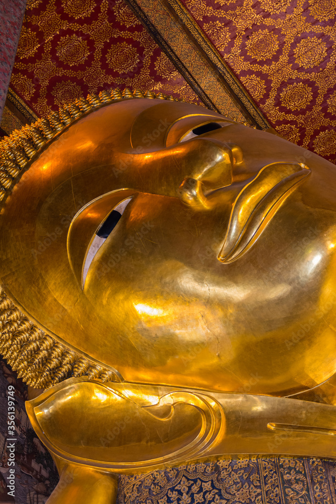 Face of reclining big Buddha gold statue in Wat Pho, Bangkok, Thailand