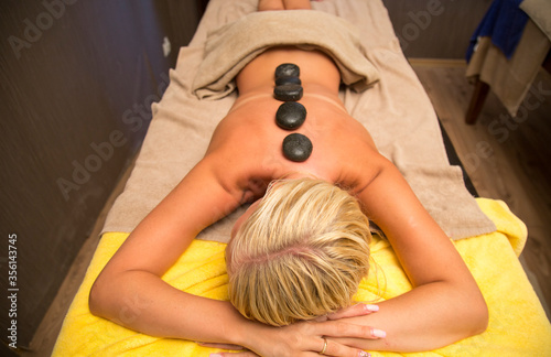 Close up of a woman relaxing on a lounger enjoys a massage in a wellness center