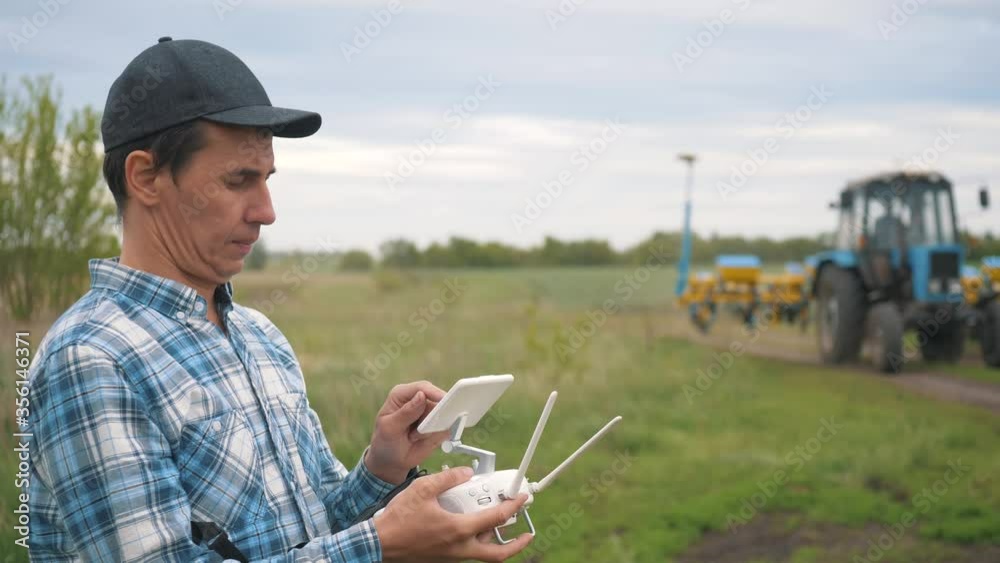 A male farmer operates an unmanned aerial vehicle to monitor the sowing of cereal seeds on agricultural land. Use of modern technologies in agriculture for high yield, good seedlings. A male farmer operates an unmanned aerial vehicle to monitor the sowing of cereal seeds on agricultural land. Use of modern technologies in agriculture for high yield, good seedlings.