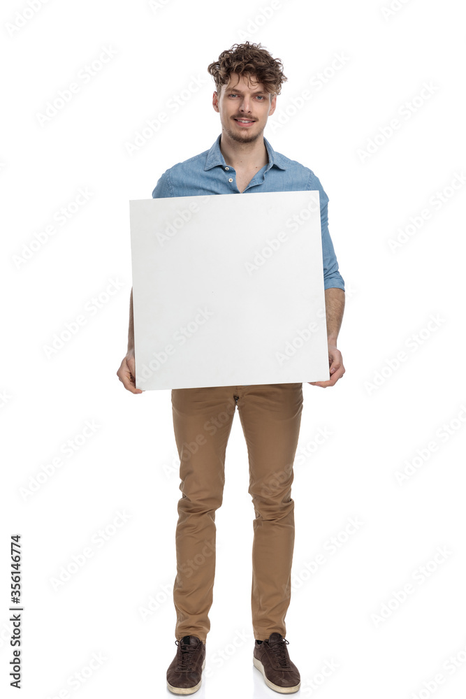 young casual guy holding empty board and smiling young casual guy holding empty board and smiling