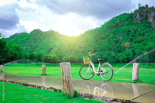 Vintage Bicycle on rainy season landscape with mountain background.