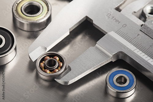 vernier caliper measures bearings against a metal background. Part of the mechanism.