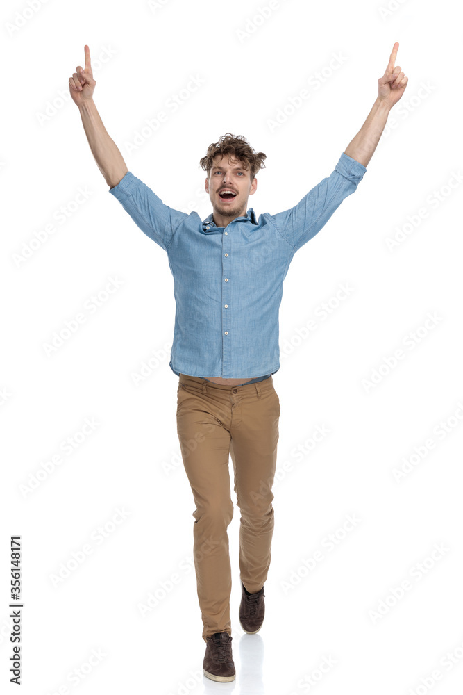 enthusiastic casual man pointing fingers in the air and celebrating