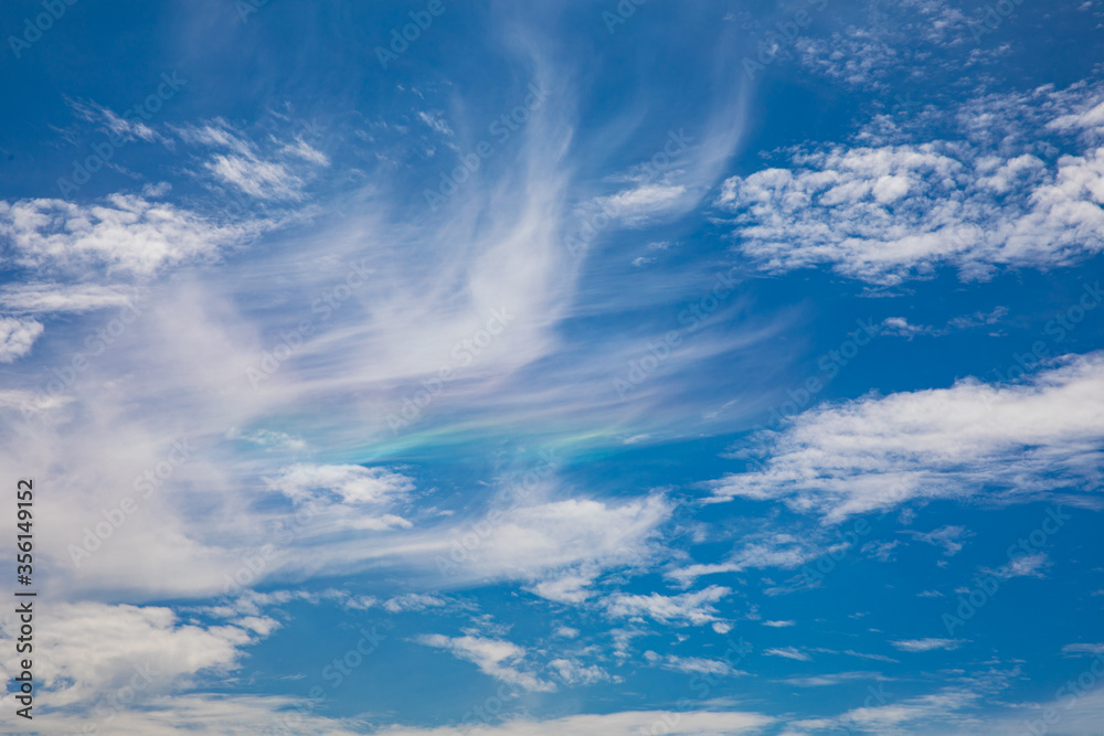 Blue sky and iridescent clouds background